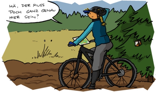 Juja steht mit Rad im Matsch neben einem Wäldchen, in dem sehr unauffällig ein Miniposten hängt, und grübelt: 'Hä, der muss doch ganz genau hier sein?